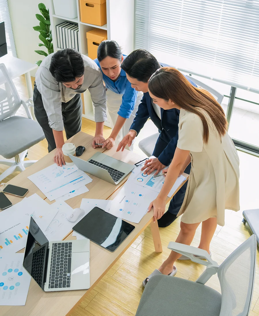 Colleagues collaborating on laptop and documents